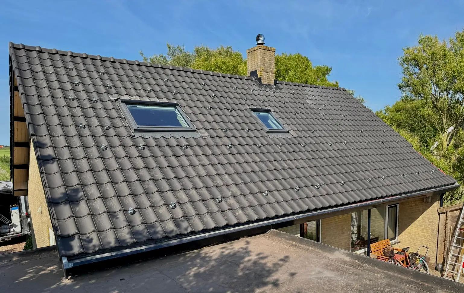 Vernieuwd pannendak met strak gelegde rijen dakpannen